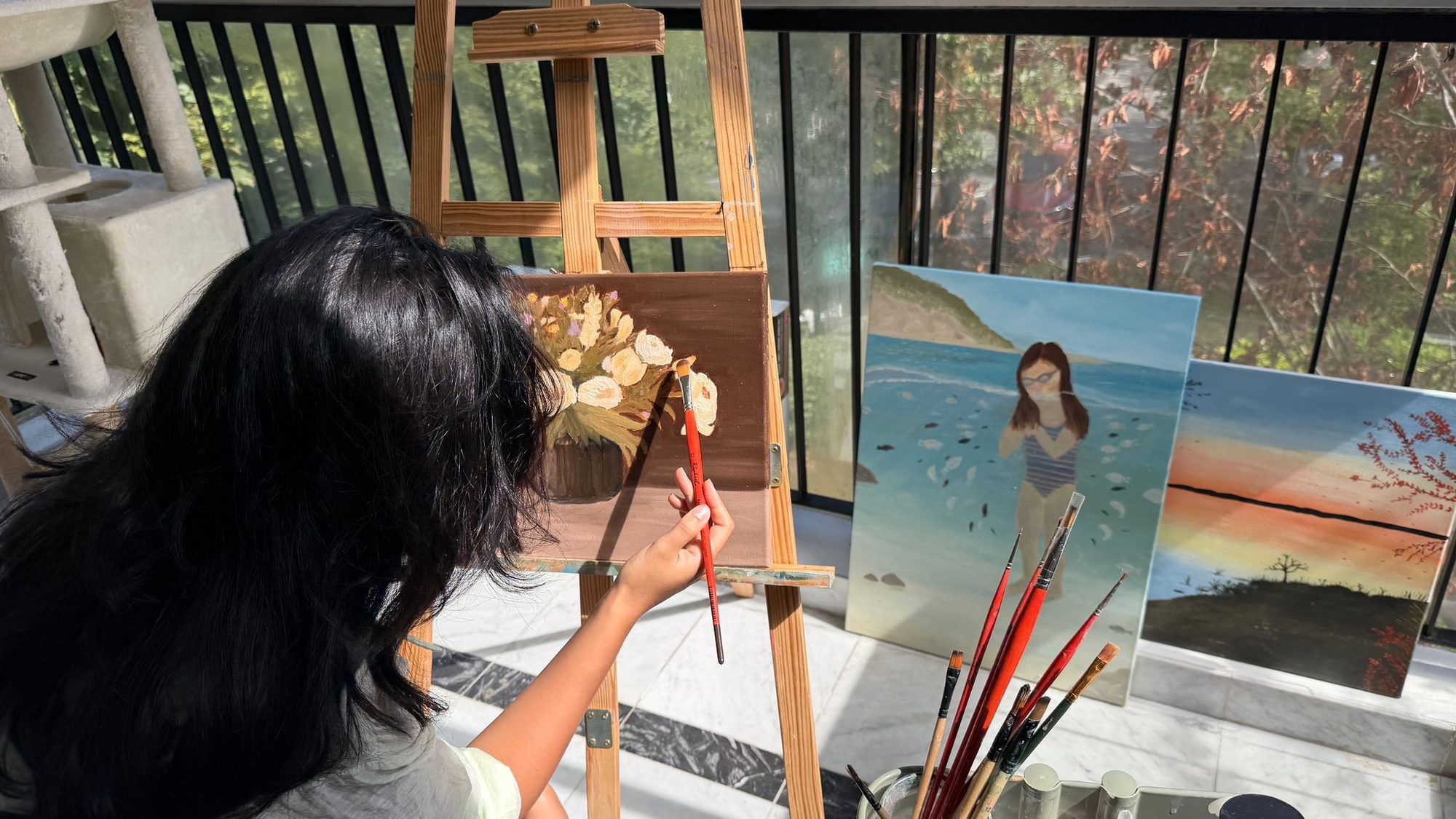 Yous painting a still life of cream roses at her easel